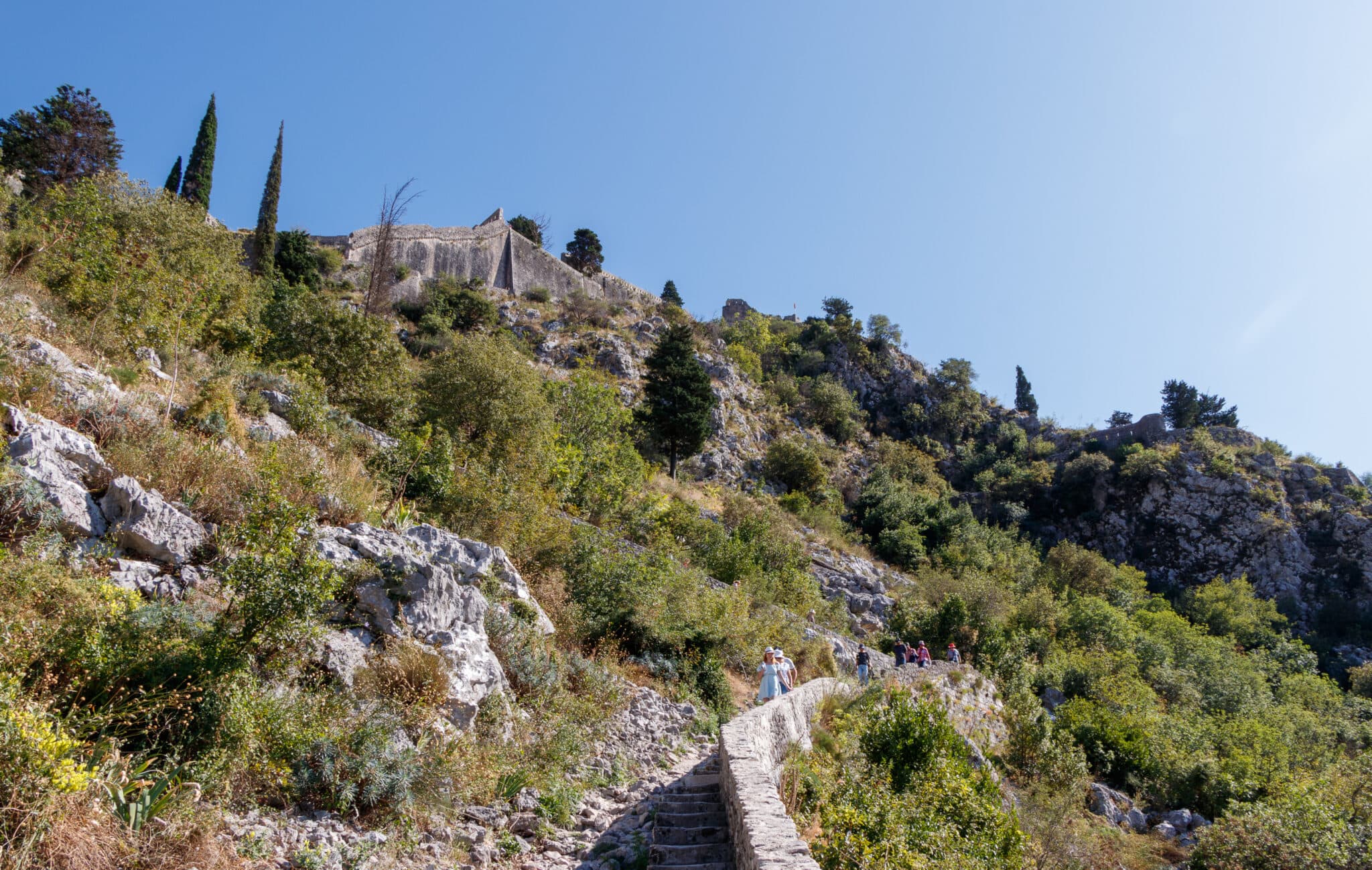 Tourists descend from the Kotor Fortress along the stone ladder in Montenegro